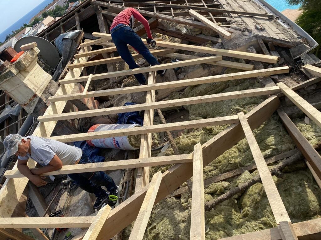 Charpentier couvreur intervenant sur des pièces de charpente en bois