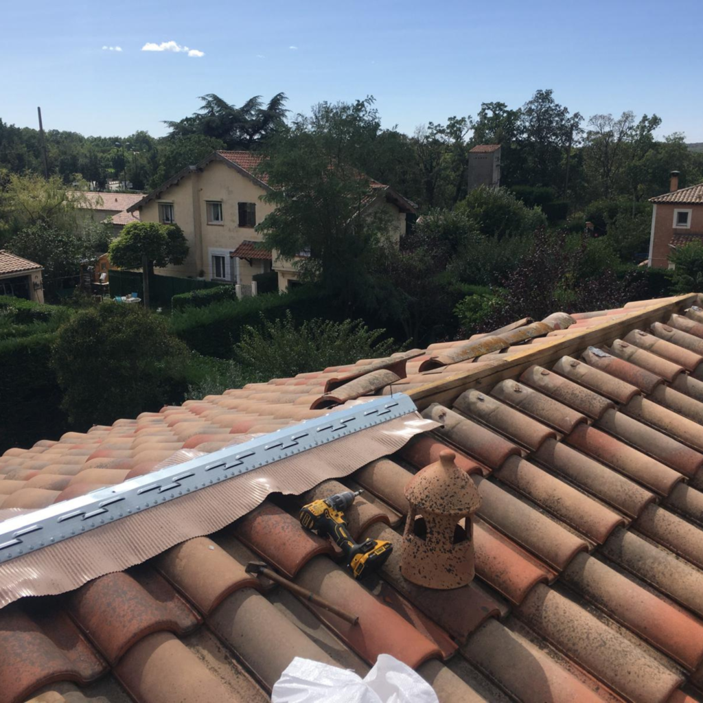 Couvreur remplaçant le faîtage d’une toiture en tuiles